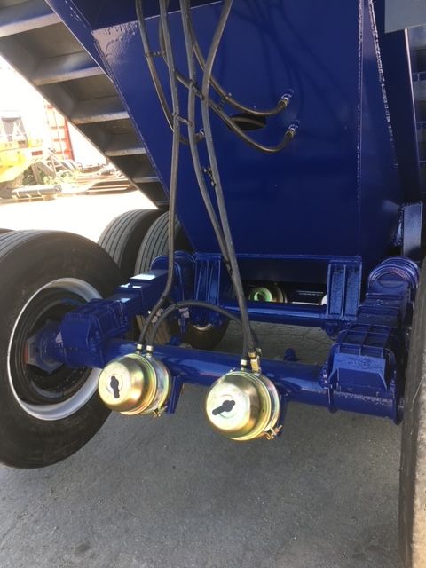 Blue utility 40 ft square dump trailer undercarriage showing axles, wheels, hoses, and hydraulic system.