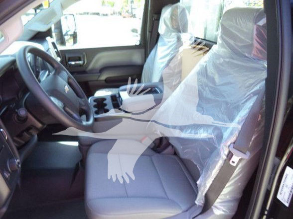 Truck interior showing driver and passenger seats with plastic protective covers; steering wheel and center console visible.