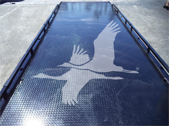 Platform bed with Isuzu truck components branding and a large graphic of two birds in flight on a diamond plate surface.