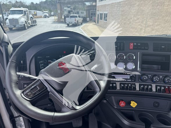 Kenworth T880 truck interior front dashboard with steering wheel and gauges visible; multiple control switches and knobs on center panel.
