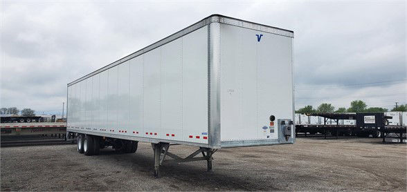 Vanguard VXP dry van trailer with raised front, white aluminum panels, and blue Vanguard logo on nose.