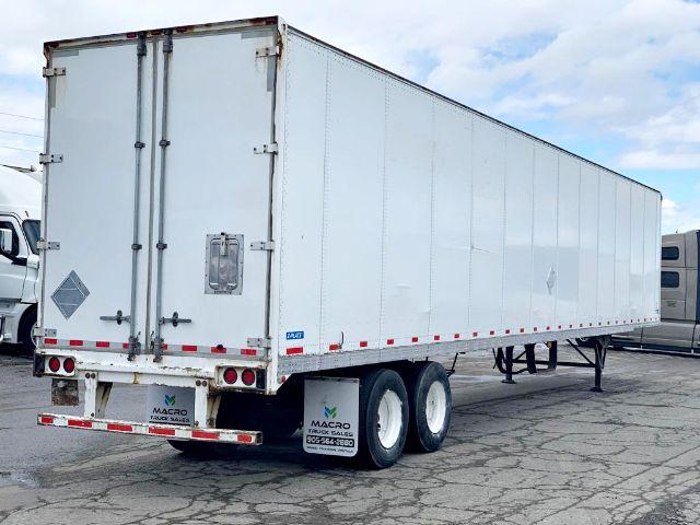 Stoughton 2009 dry van trailer showing side and rear doors with dual rear axles and white exterior.