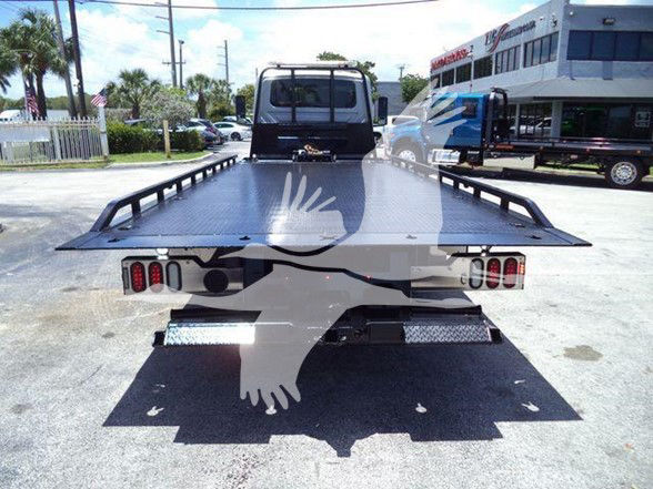 Tow truck flatbed rear view showing taillights and diamond plate bed.