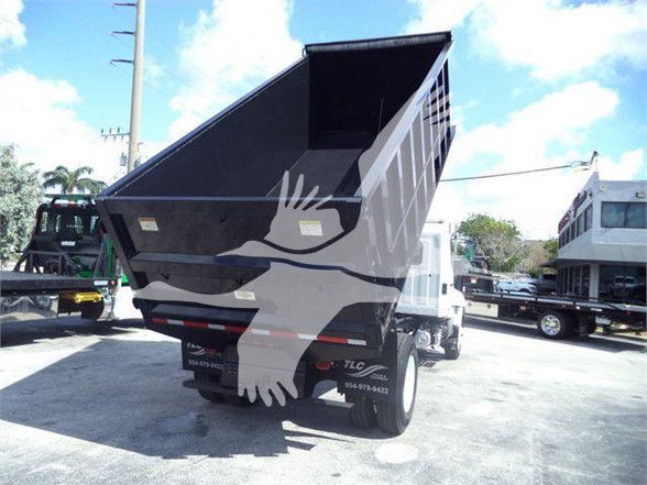 2016 Hino 268A dump truck rear with raised dump bed, stickers and tail lights visible.