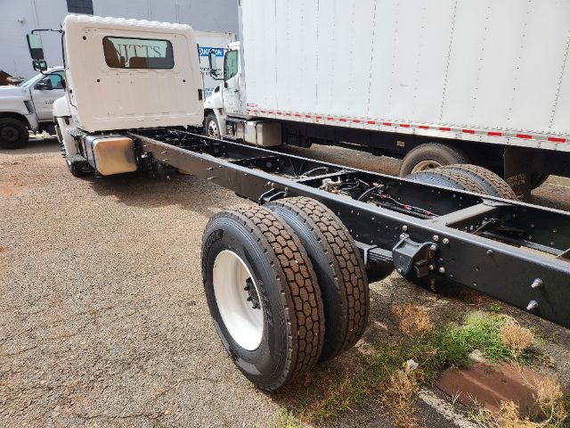 Chassis cab showing rear dual rear wheels and truck frame with white cab and black chassis.