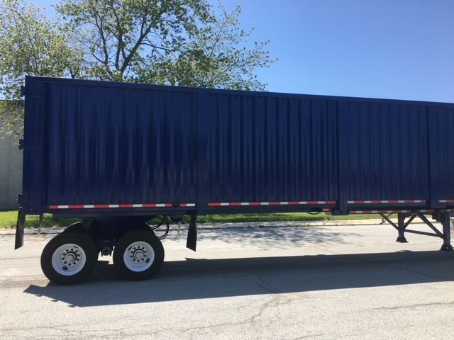 Blue 40 ft utility dump trailer side view with dual rear wheels and red-and-white reflectors.