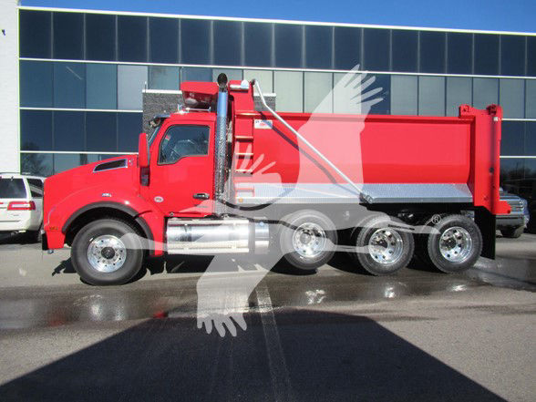 Kenworth T880 dump truck side view showing red cab and dump body with chrome fuel tanks and wheels.