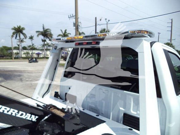 Ford F-450 tow truck rear pickup with window guard and light bar.