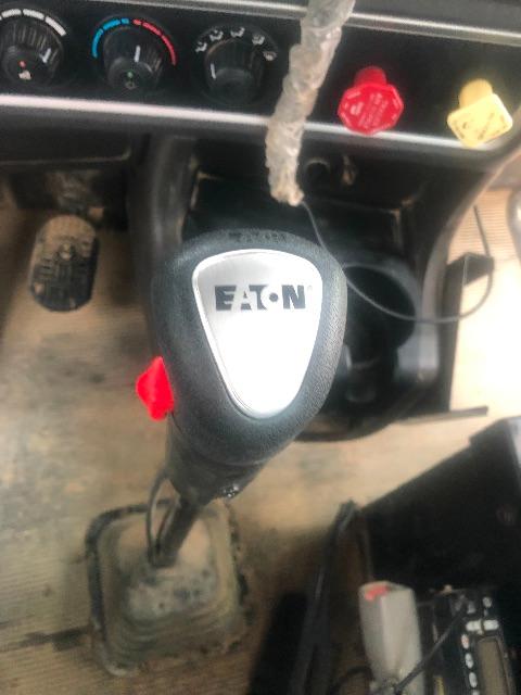 Eaton shift knob in Kenworth T800 cab with dashboard controls and ignition area visible.