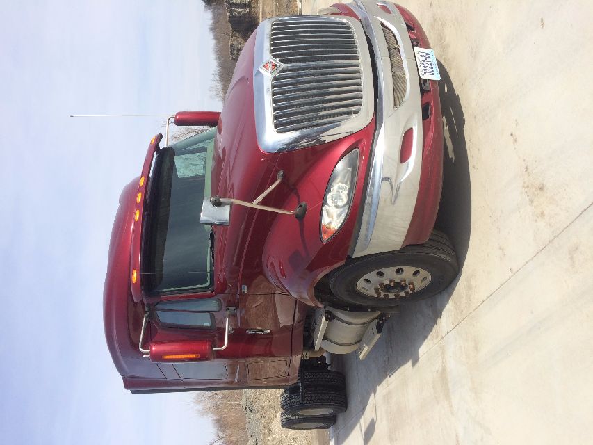 2011 International Prostar truck front-left view with maroon cab and chrome grille.