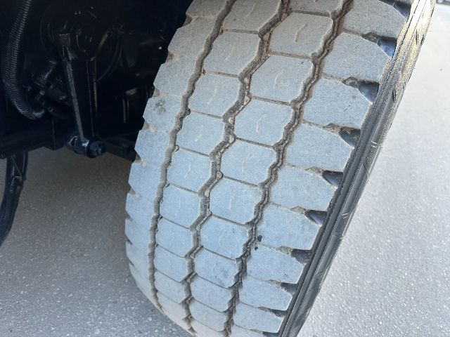 Truck wheel displaying detailed tread pattern with dual seams, part of a heavy-duty International 7400 vacuum truck.
