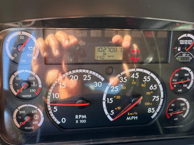 Dashboard view of a 2014 Freightliner 114SD showing RPM gauge, speedometer, diagnostic display, and multiple gauges including oil, water, trans temp, and air pressure.