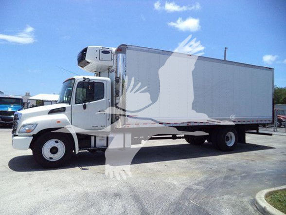 Truck with reefer body showing side view of refrigerated trailer on a white cab chassis.
