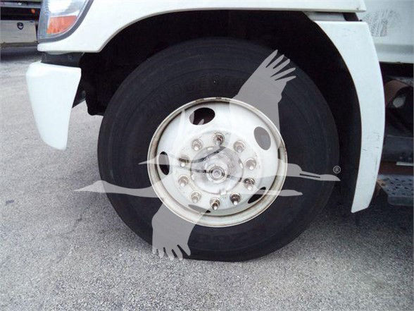 Truck front wheel with white fender and hub, no visible text other than wheel bolts.