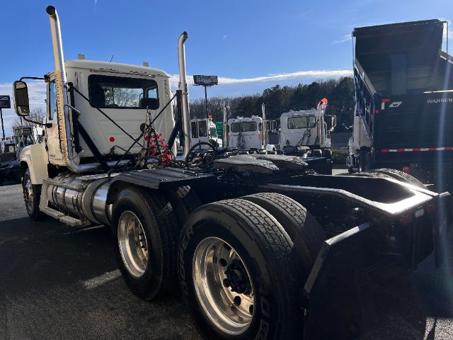 Semi tractor chassis showing rearview with twin rear axles, fifth wheel, fuel tanks, and exhaust stacks.