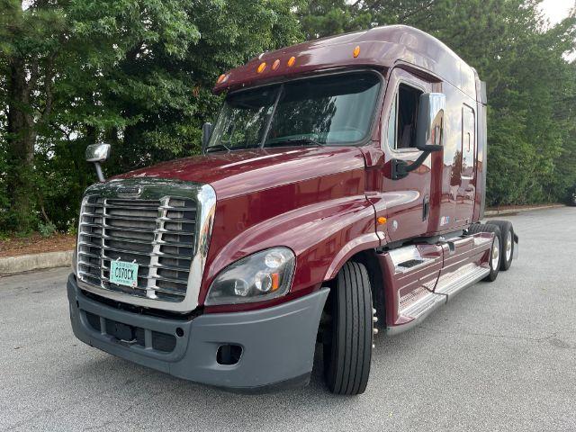 2015 Freightliner Cascadia conventional sleeper truck in maroon with chrome grille and bumper, shown angled front-right; visible dual rear axles and side steps.