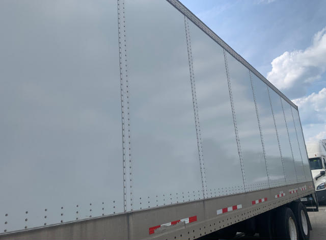 Trailer side panel of a 2019 Vanguard VXP utility trailer with riveted aluminum sides and red/white reflective strips.