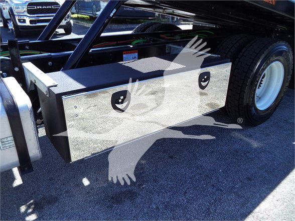 Isuzu FTR truck chassis with aluminum toolbox mounted near the rear wheel; visible storage box with two circular cutouts and textured top.
