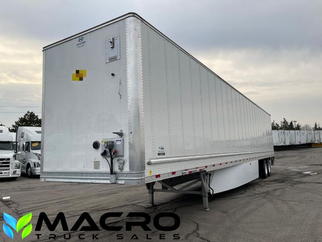 Trailer side view showing a white Hyundai dry van freight trailer with dual rear wheels and MACRO Truck Sales logo at bottom left.