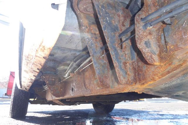 Underbody view of a 2011 Chevrolet 2500HD pickup showing rusted chassis and underside components
