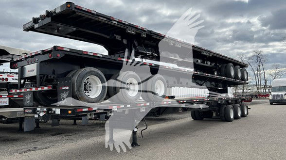 Manac extendable flatbed trailer with multiple axles and extended deck in view.