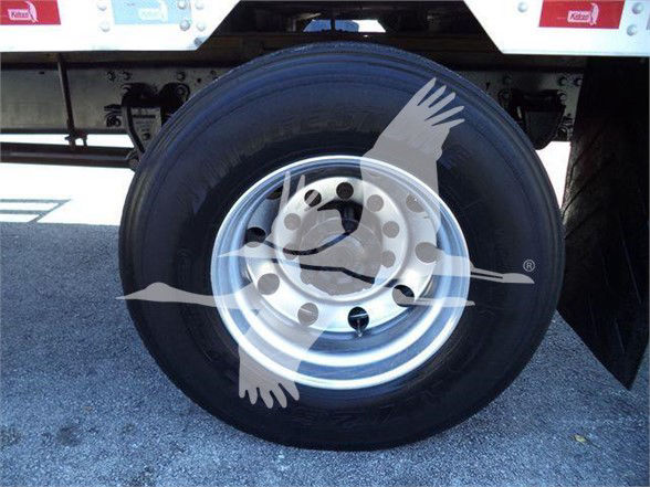 Truck wheel with tire and silver steel rim in reefer truck undercarriage