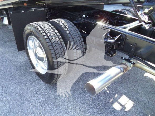 Truck chassis rear section with dual rear wheels and exhaust outlet visible underbody components and frame rails.