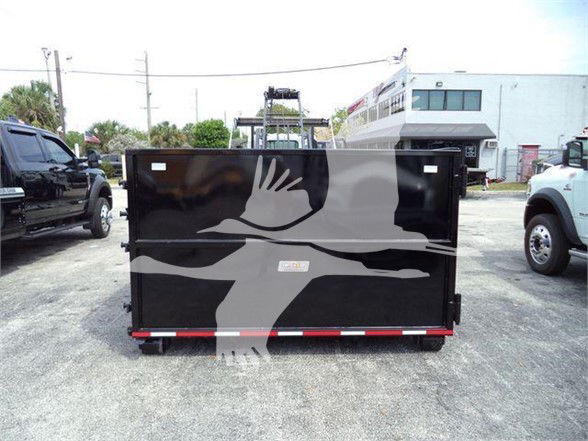 Isuzu NRR dump truck in lot, rear view showing solid black container with graphic watermark and red/white reflective stripe at bottom.