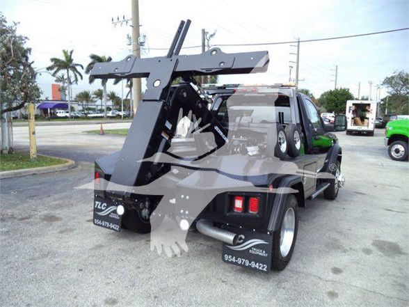 Tow truck rear view showing heavy-duty carrier with winch, hydraulic arms, and dual rear tires on a 2024 RAM 4500 SLT tow rig.