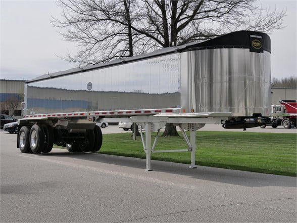 Trailer: 2023 Alum lightweight frameless dump trailer with polished stainless sides, tandem axles, adjustable legs, and a black tarp along top edge.