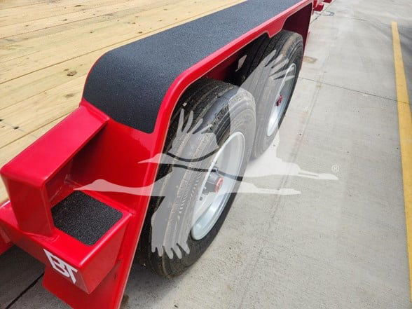 Behnke trailer wheel area showing dual tires and red fender with black fender cover.