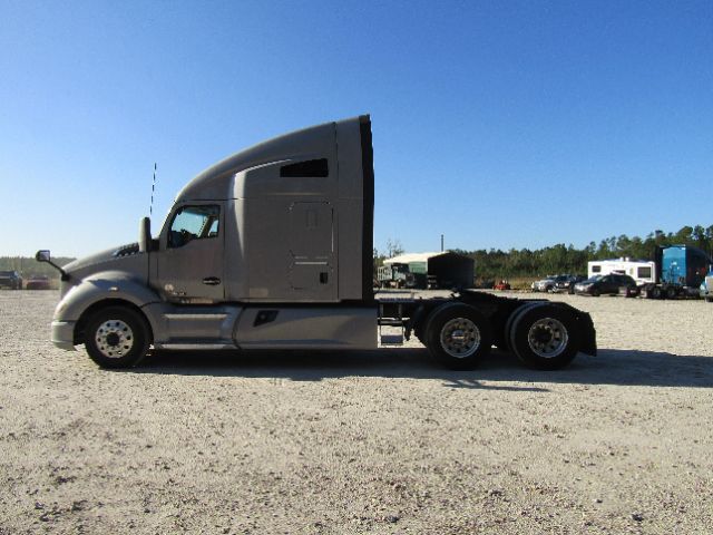 Kenworth T680 cab and chassis truck side view in a gravel lot.