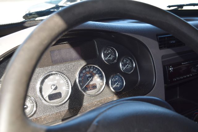 Peterbilt 337 cockpit dashboard and gauges seen through steering wheel.