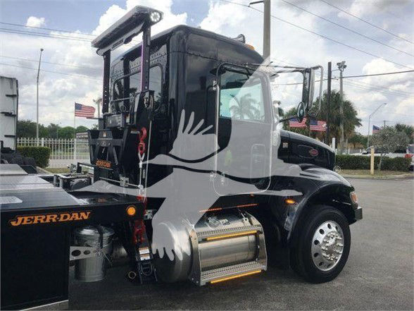 Peterbilt 337 tow truck cab exterior, black with chrome fuel tank, side step, and rear mounting hardware visible.