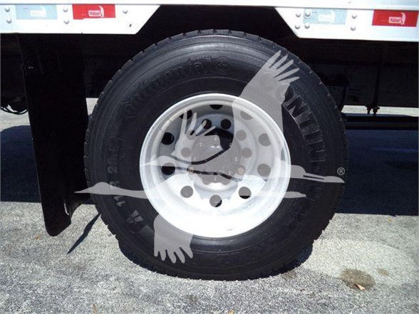 Truck wheel with tire and white rim showing hub and valve stem; trailer undercarriage visible; part of Reefer truck listing.