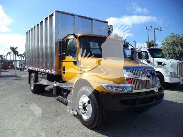 Truck engine bay area with yellow cab and aluminum cargo bed; no readable labels visible in this view.
