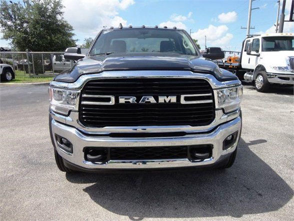 Tow truck front view showing RAM grille and chrome bumper on 2024 Ram 5500 SLT in dealership lot.