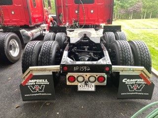 Trailer hitch area showing dual rear axles and mud flaps with 'CAMPBELL' logos; license plate area and lights visible.