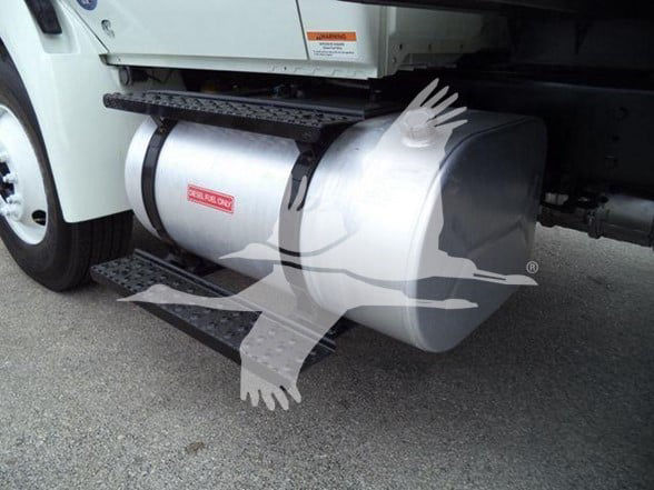 Truck fuel tank with safety label visible; part of International DURASTAR 4300 2019 model. Fuel tank showing warning label and steps along the frame.