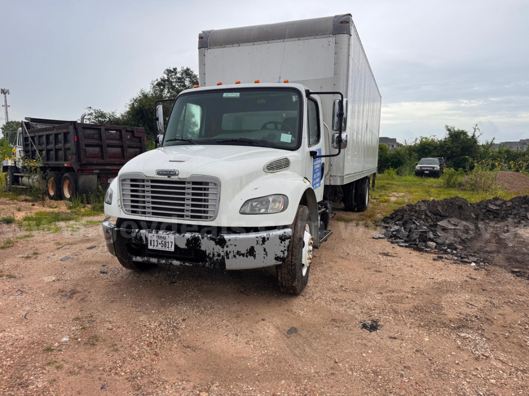 Freightliner M2 106 box truck front-left view showing white cab and large cargo box.