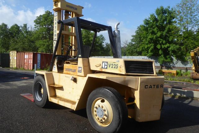 Caterpillar V225 forklift in service shown from side angle with yellow paint, black overhead guard, and large front exhaust area.