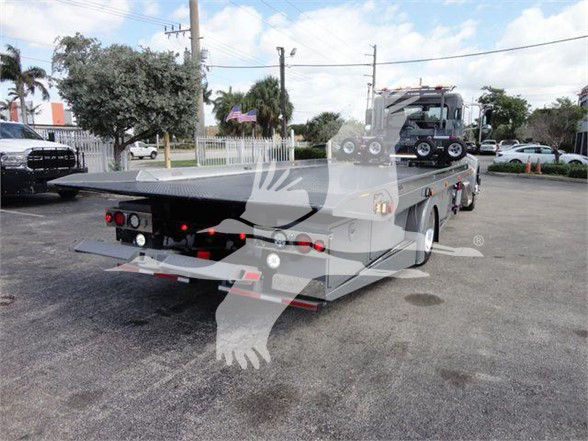 Peterbilt 337 tow truck flatbed rear view showing ramps and equipment on bed.