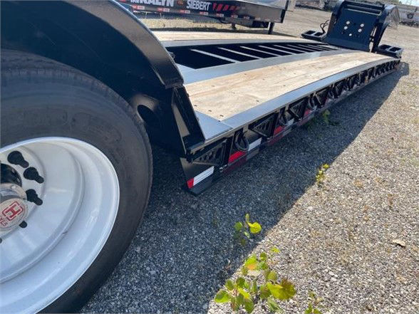 Fontaine 55 ton steel lowboy flatbed trailer showing 26 ft deck, black frame, wooden deck surface, dual rear wheels, and side rails.