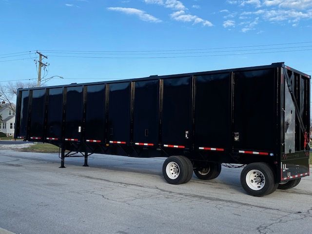 Crush car carrier trailer in black with dual rear wheels and elevated front legs, 48 ft trailer length.