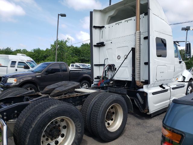 2015 International PROSTAR tractor cab rear quarter showing exhaust stack and chassis with dual rear axles and tires.