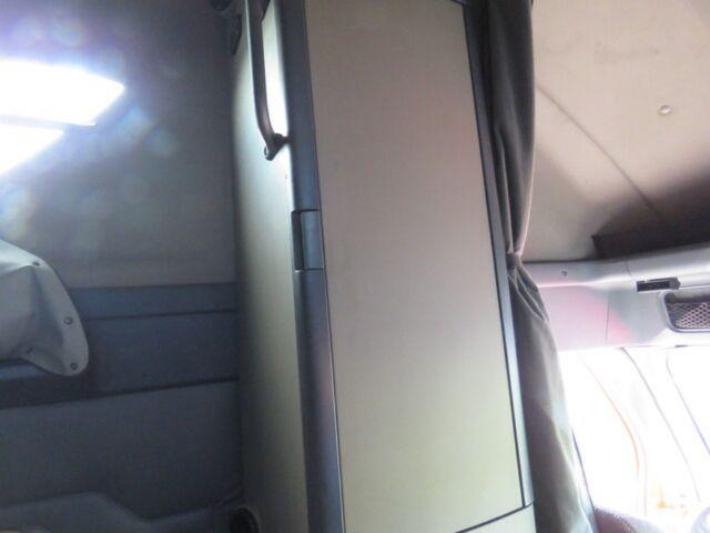 Interior of a Freightliner Cascadia Evolution truck cab showing a vertical partition and door panel, with beige/gray interior and seat visible.