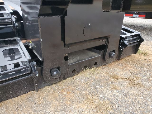 Front lower frame of a lowboy trailer showing heavy steel hull and attachment points with bolts; no visible text legible.