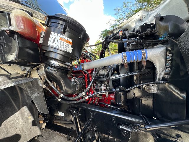 Freightliner 114SD engine bay showing air intake, hoses, and hydraulic lines.