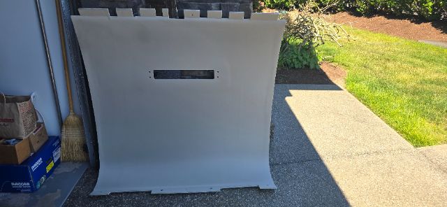 Truck cabin sleeper panel or interior bulkhead part with a rectangular cutout, placed outdoors on a driveway.