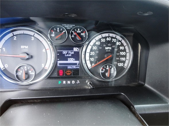 Dashboard of a 2012 Ram 3500 SLT showing RPM gauge, speedometer, DEF fluid level, and gear selector in P R N D with digital display.